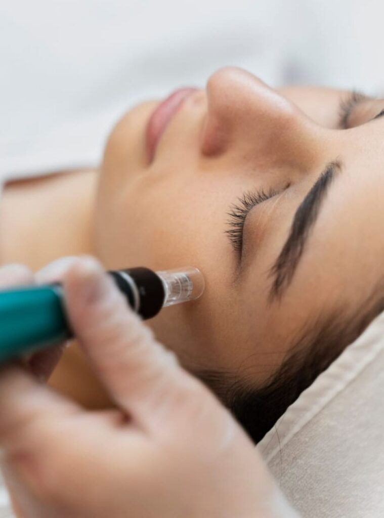 joven en camilla recibiendo tratamiento facial con dispositivo estetico en clinica profesional